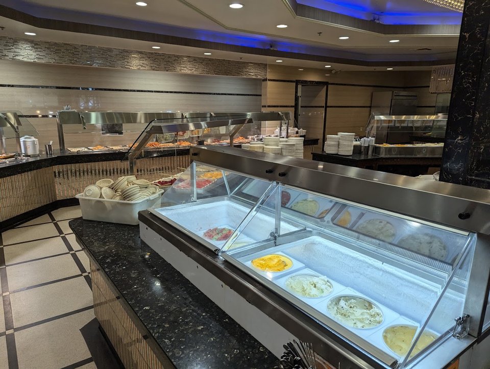 Salad bar beside warm buffet stations